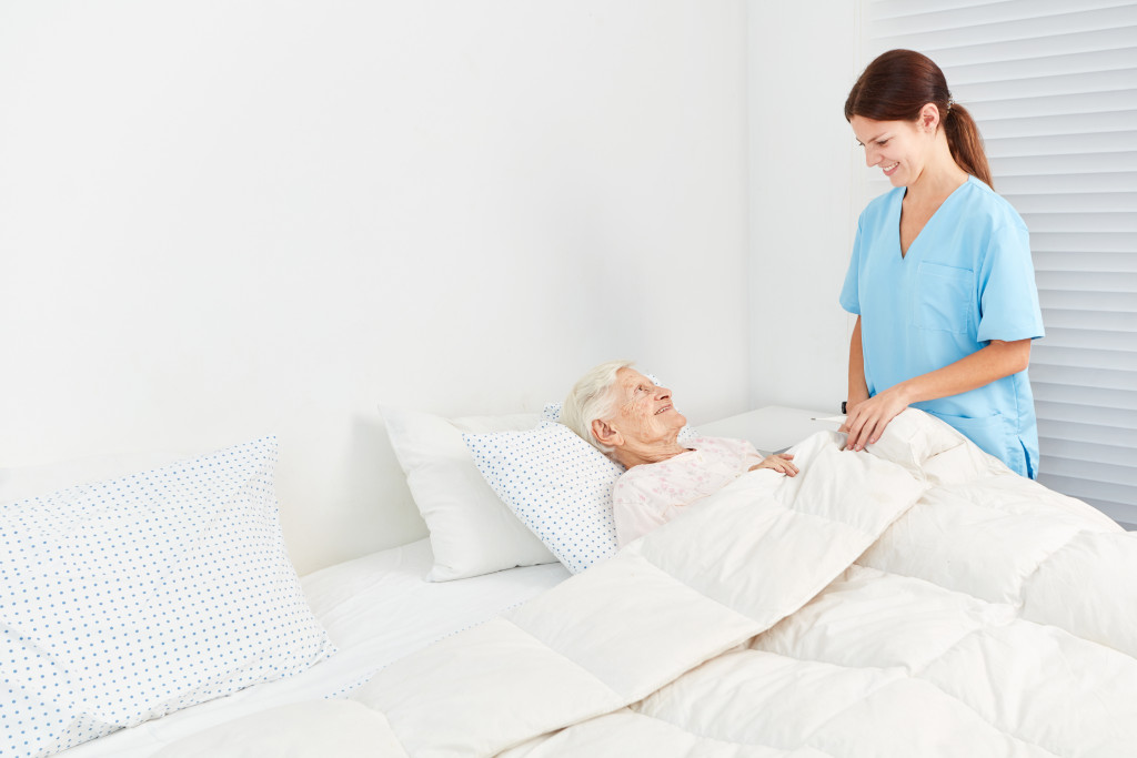 nurse taking care of old woman
